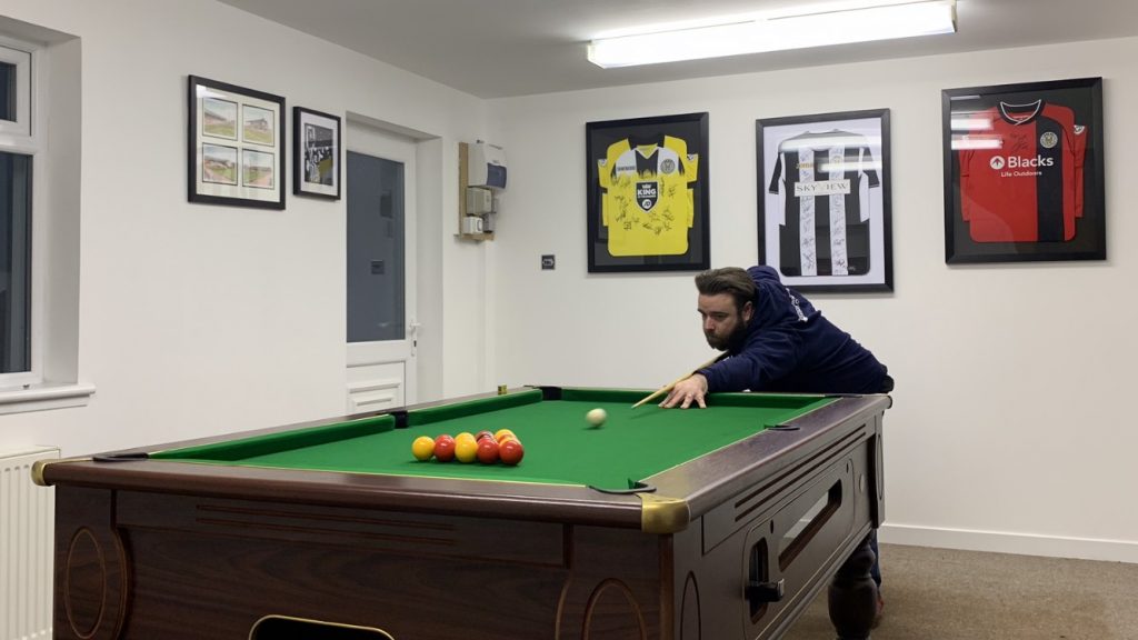 John playing pool to avoid burnout in IT